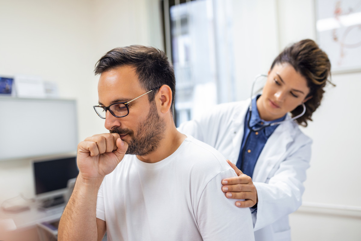 Una doctora en la clinica realiza la auscultacion de los pulmones de un paciente con sintomas de coronavirus o neumonia