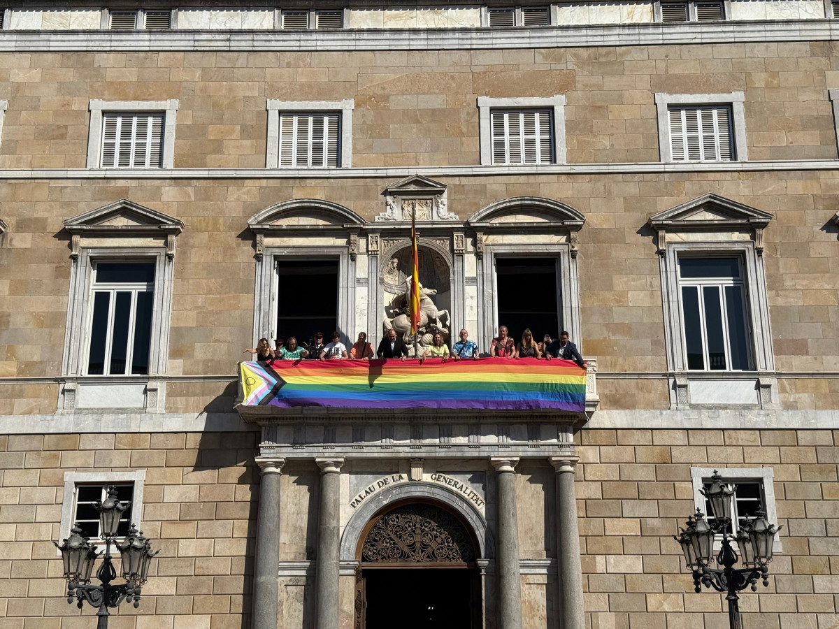 El conseller de la Presidencia de la Generalitat, Albert Dalmau, y la consellera de Igualdad y Feminismo, Eva Menor, despliegan este sábado una bandera LGTBIQ+ en el balcón del Palau de la Generalit