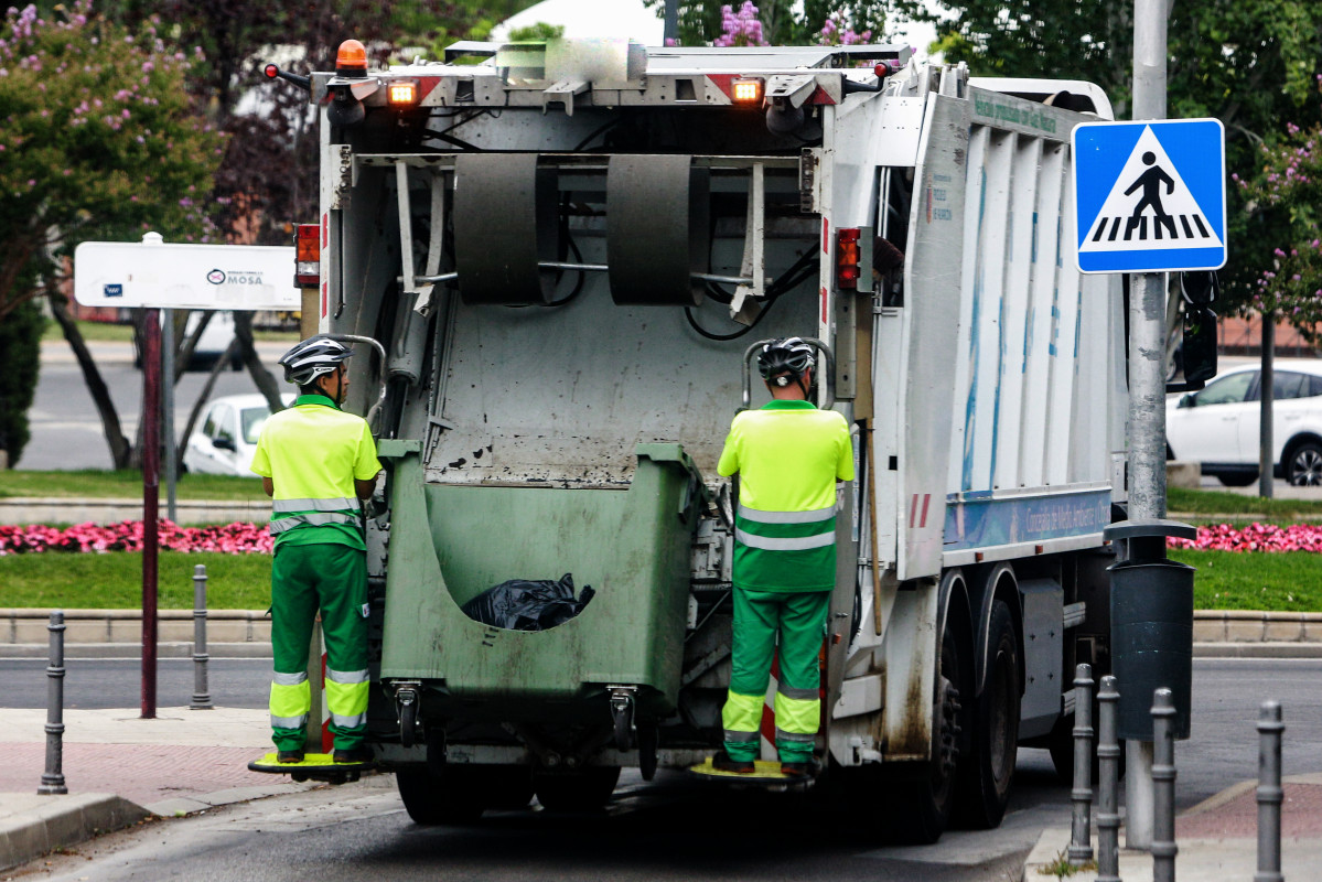 EuropaPress 2312028 dos trabajadores servicio recogida basuras vacian contenedor camion
