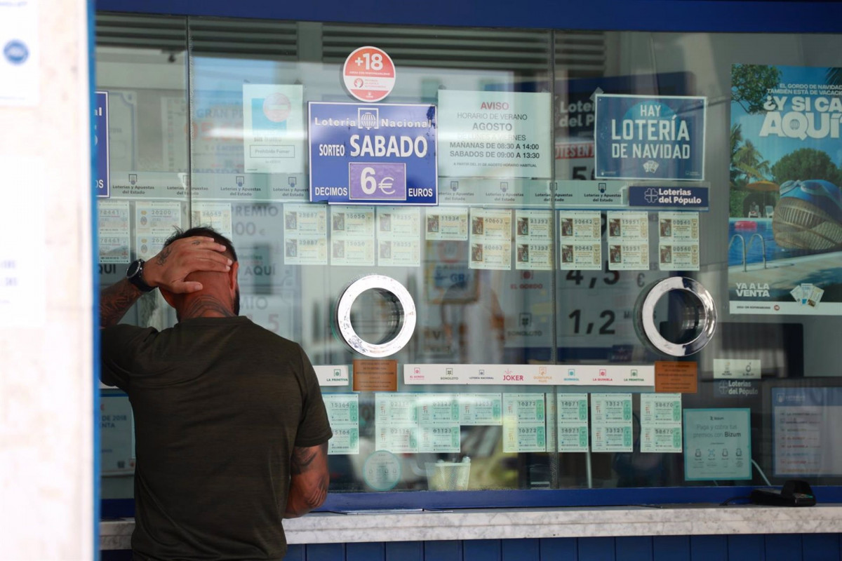 Archivo - Una persona se dispone a adquierir un boleto en una Administración de Loterias/Archivo