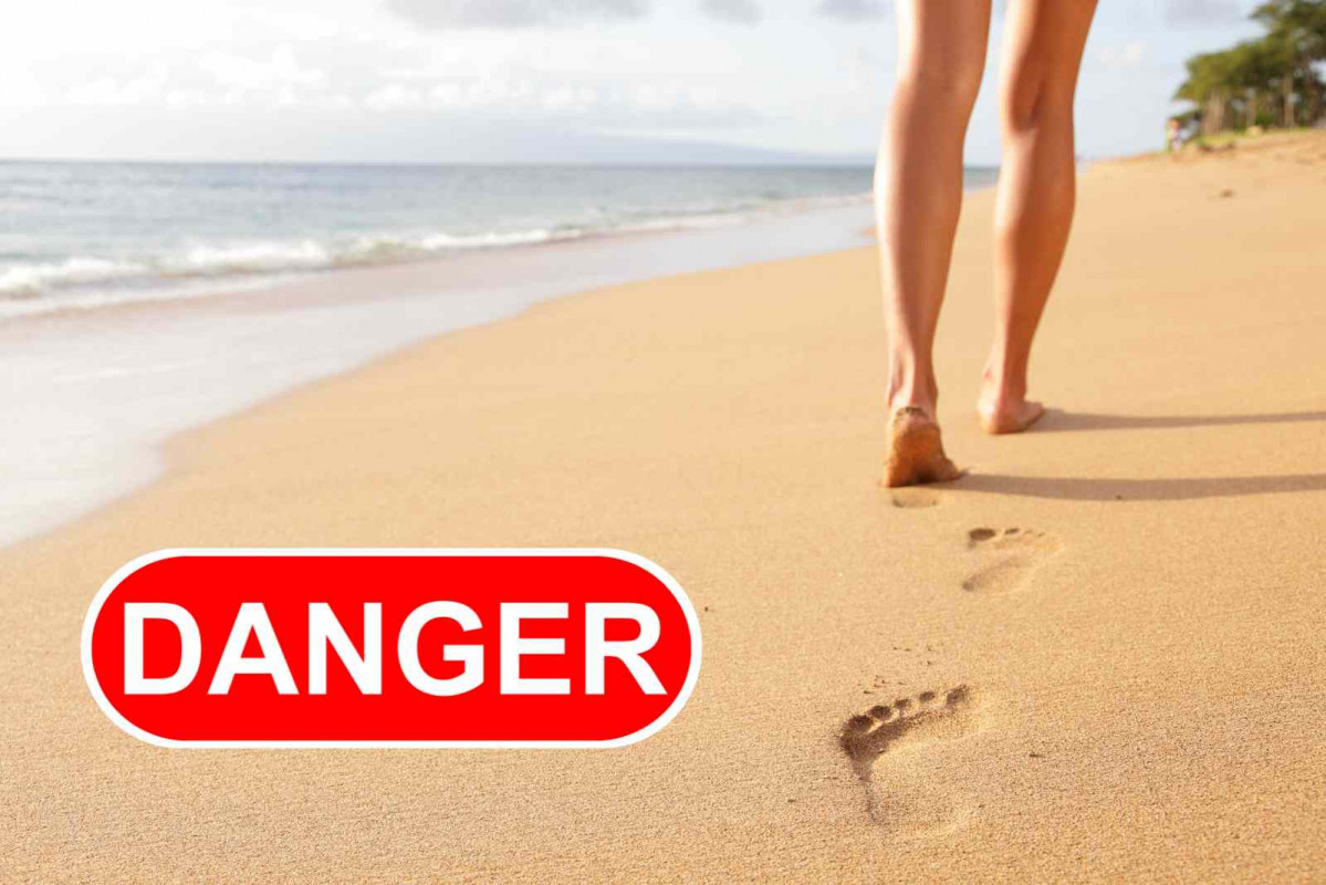 Una mujer camina por la playa; peligro   CANVA