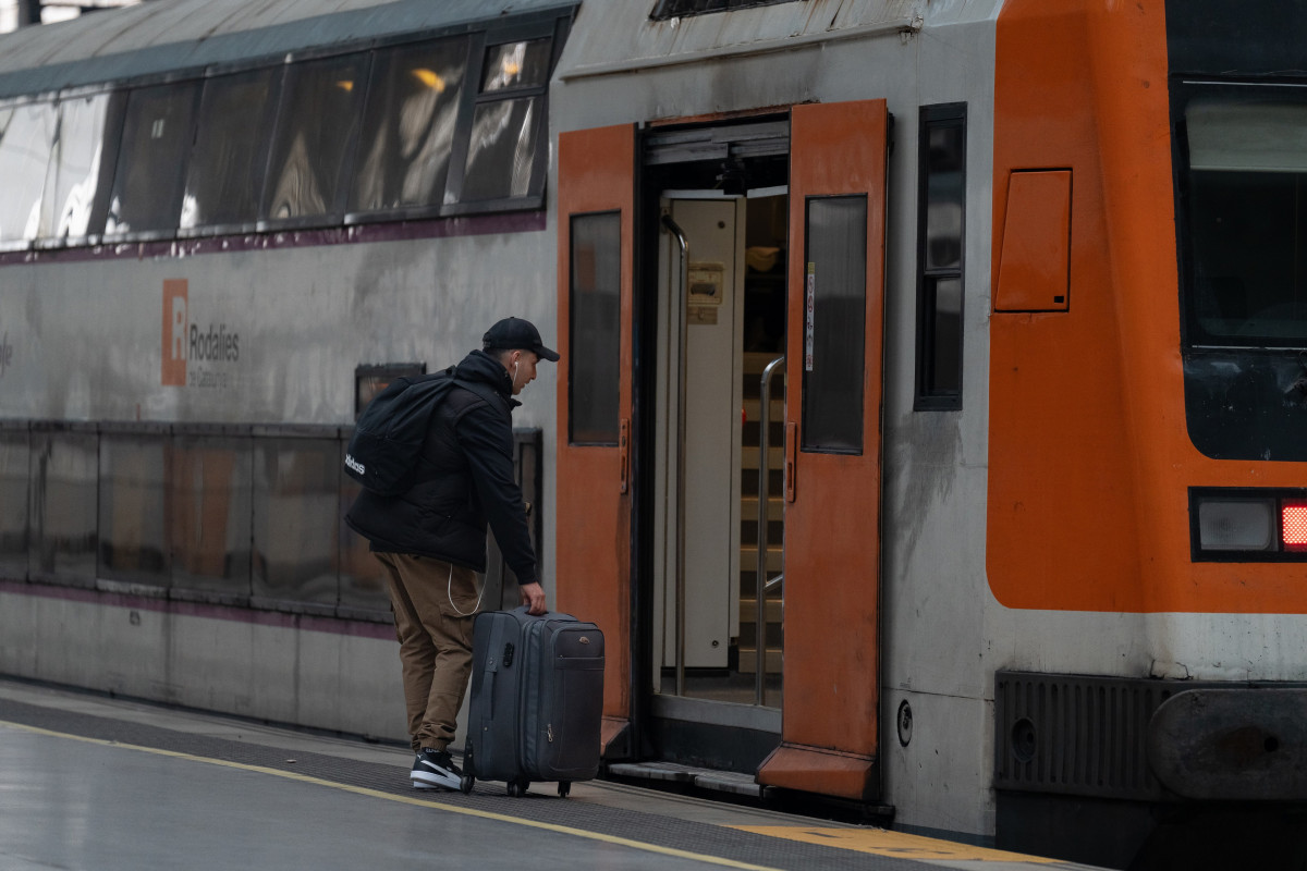 Archivo - Una persona accediendo a un tren de Rodalies.