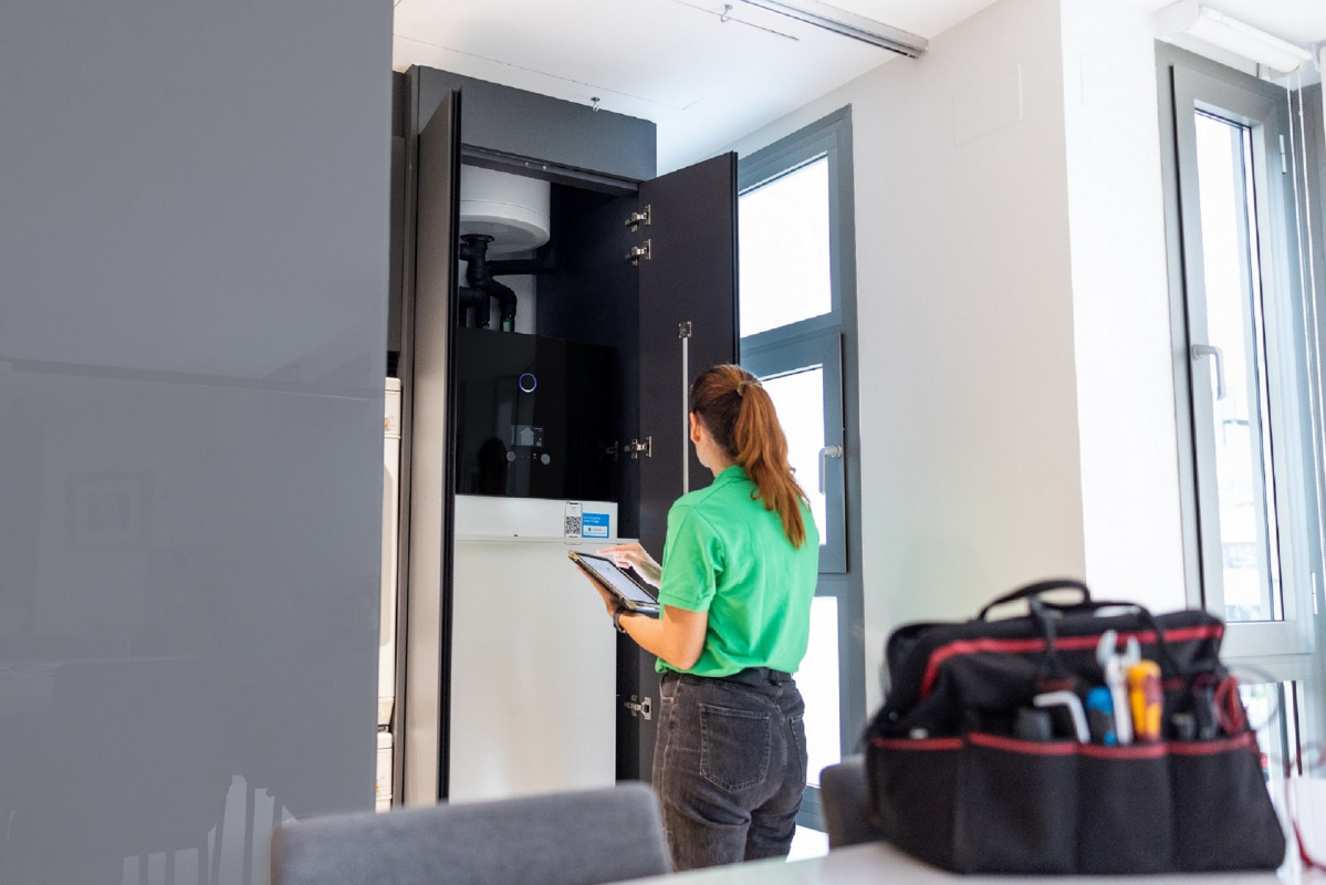 Técnico de Iberdrola ante la unidad interior de aerotermia en una vivienda