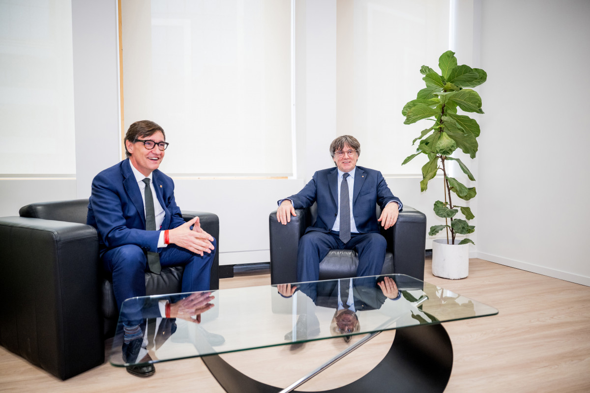 El presidente de la Generalitat, Salvador Illa (i), saluda al presidente de Junts per Catalunya, Carles Puigdemont (d)