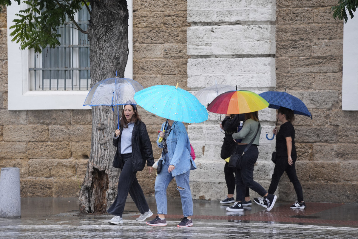 Archivo - Transeuntes bajo sus paraguas durante la intensa lluvia. A 11 de octubre de 2024, en Cádiz (Andalucía, España). La Agencia Estatal de Meteorología (Aemet) ha activado para este viernes a