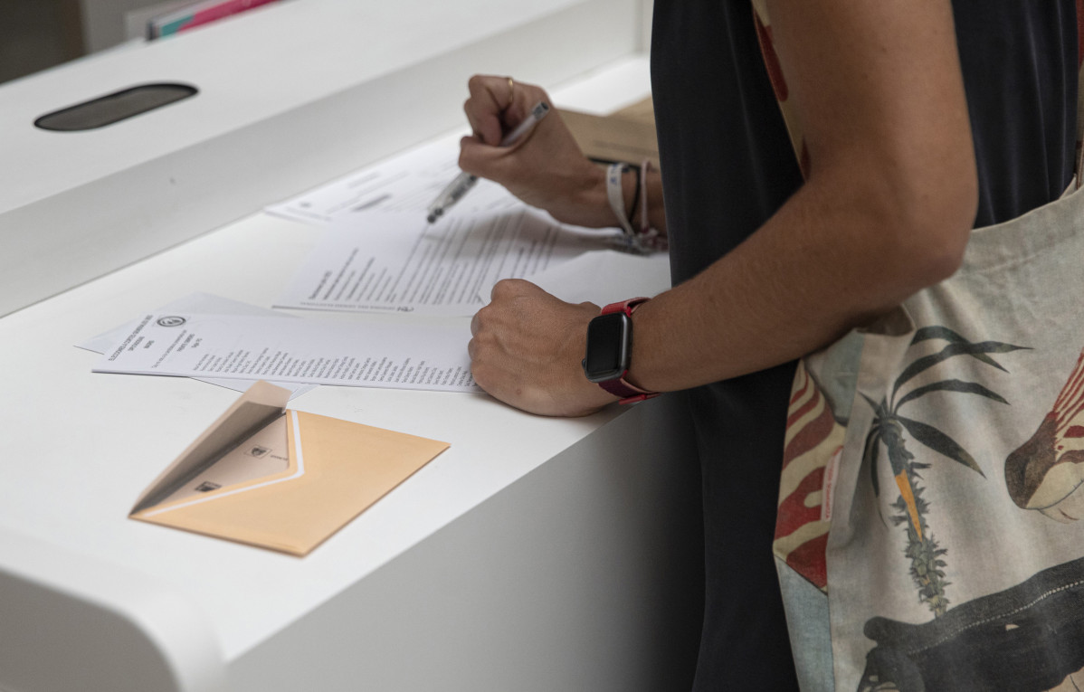 Archivo - Una mujer votando por correo en unas elecciones.