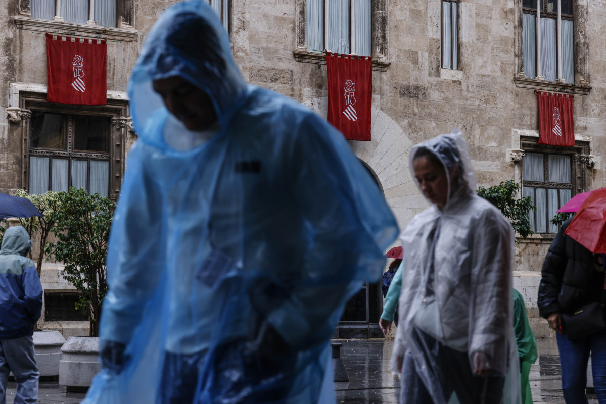 Varias personas con chubasqueros pasean, a 9 de octubre de 2025, en Valencia, Comunidad Valenciana (España). La Agencia Estatal de Meteorología (AEMET) ha activado la alerta naranja por precipitacio
