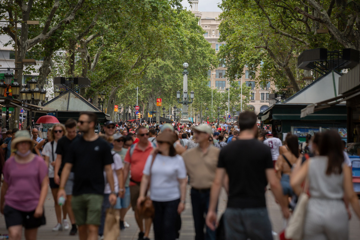 Archivo - Centenares de personas caminan por Barcelona, en una imagen de archivo