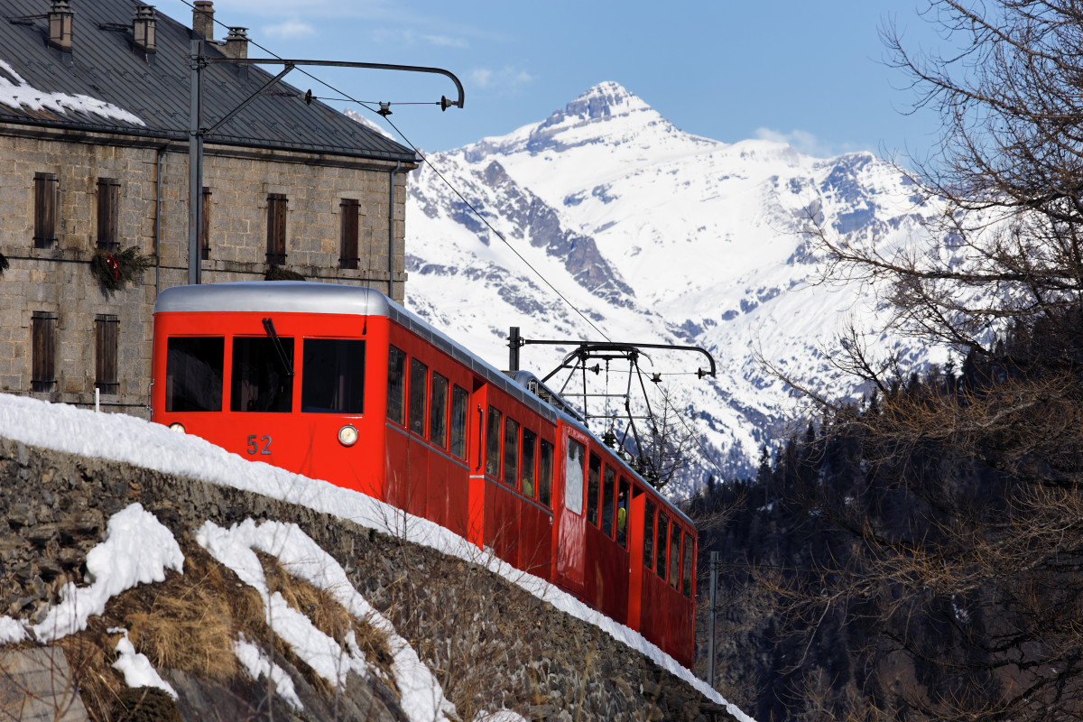 Tren rojo en la montana alpina francesa en invierno