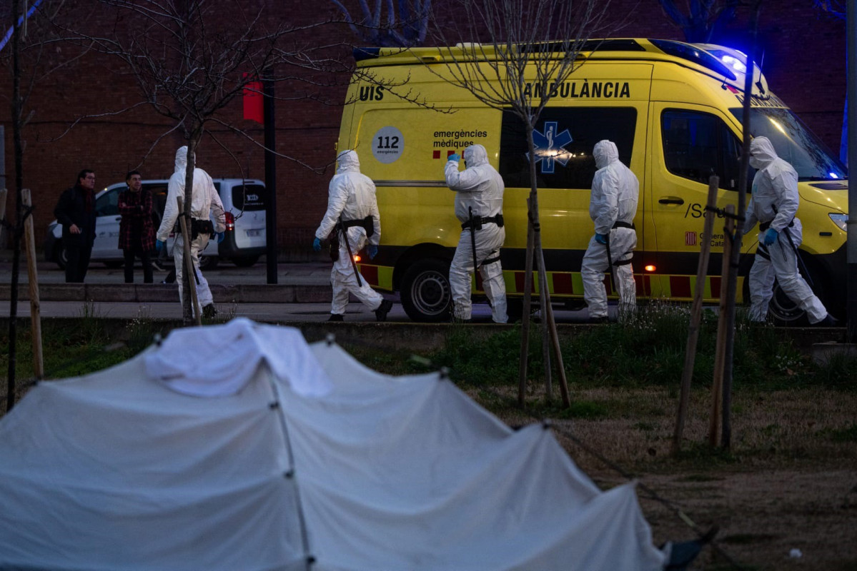 Técnicos sanitarios durante el retiro de parte de un campamento en la Zona Franca de Barcelona por motivos sanitarios este martes