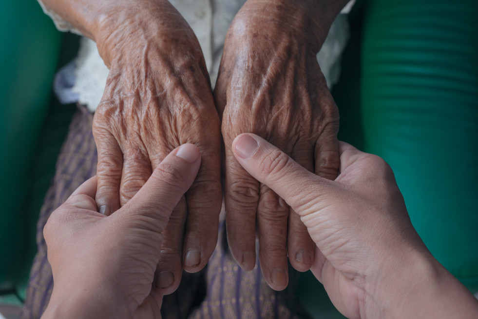 Young woman holding elderly woman s hand