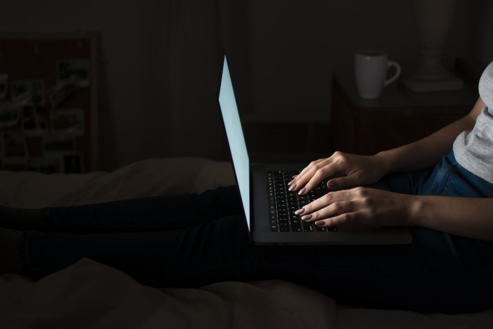 Side view woman working late home laptop