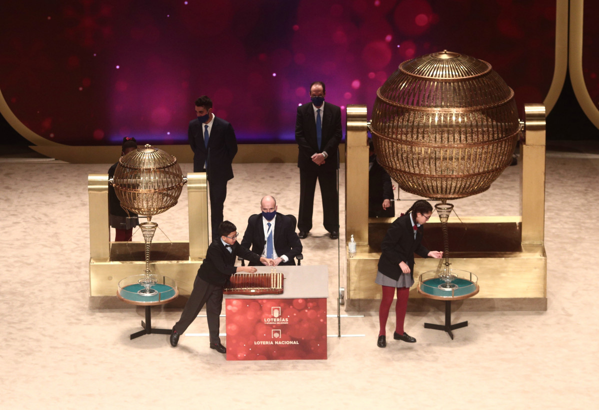 Dos de los niños de la residencia de San Ildefonso Salvador Constantin Roaan y Noura Akrouh cantan algunos de los premios durant la celebración del Sorteo Extraordinario de la Lotería de Navidad 2020 en el Teatro Real de Madrid (España), a 22 de diciembre