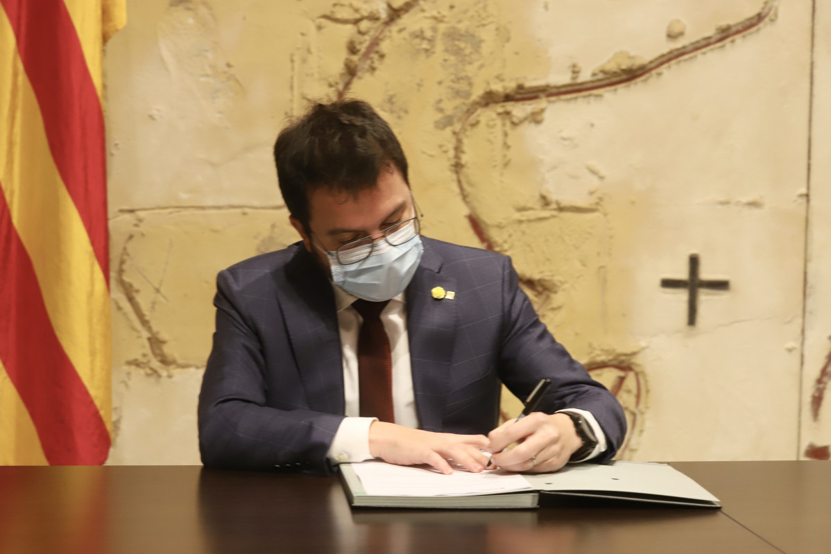 El vicepresidente de la Generalitat, Pere Aragonès, firma el decreto que pospone las elecciones catalanas hasta el 30 de mayo.