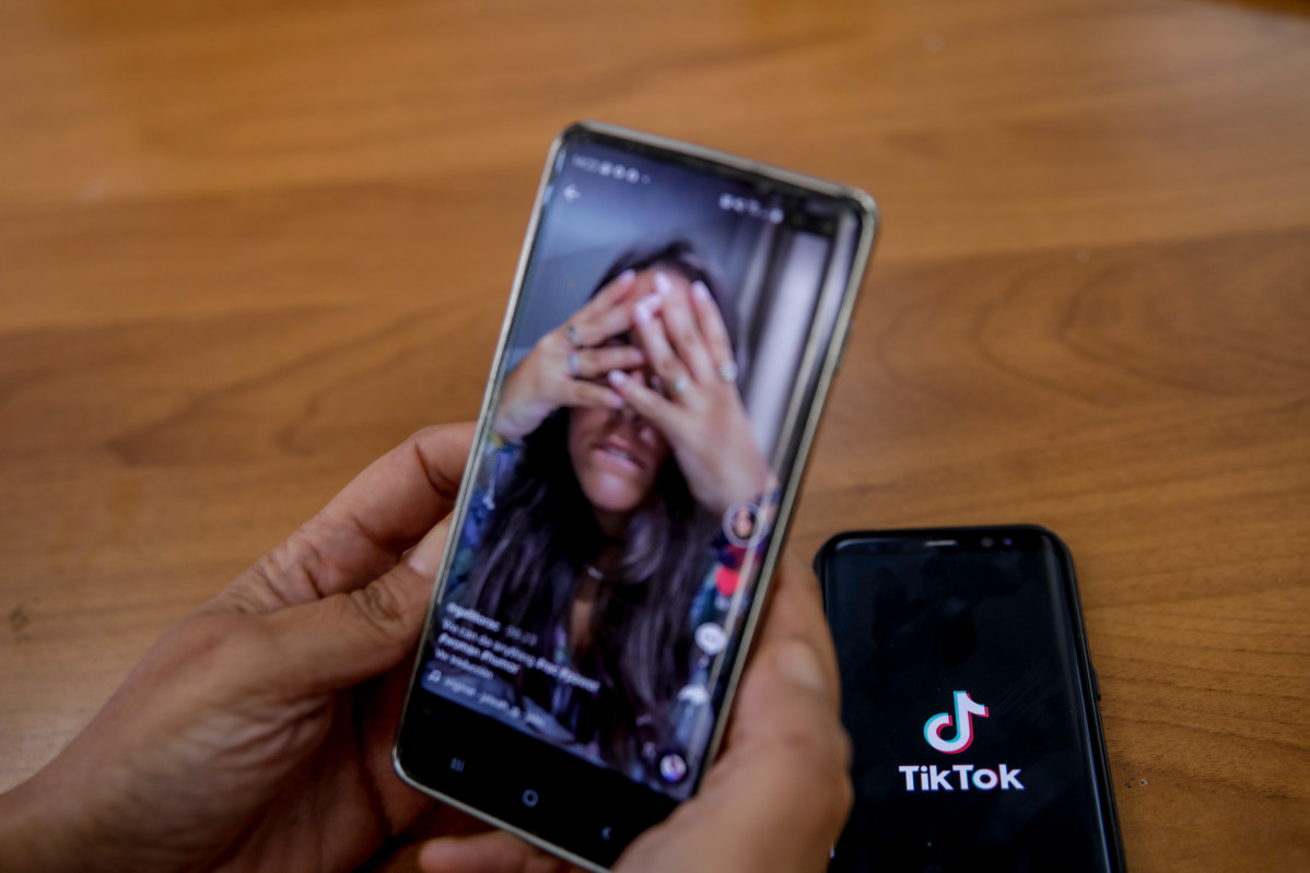 Una persona mira en super móvil el vídeo de una joven en la red musical Tik Tok, en Madrid (España).
