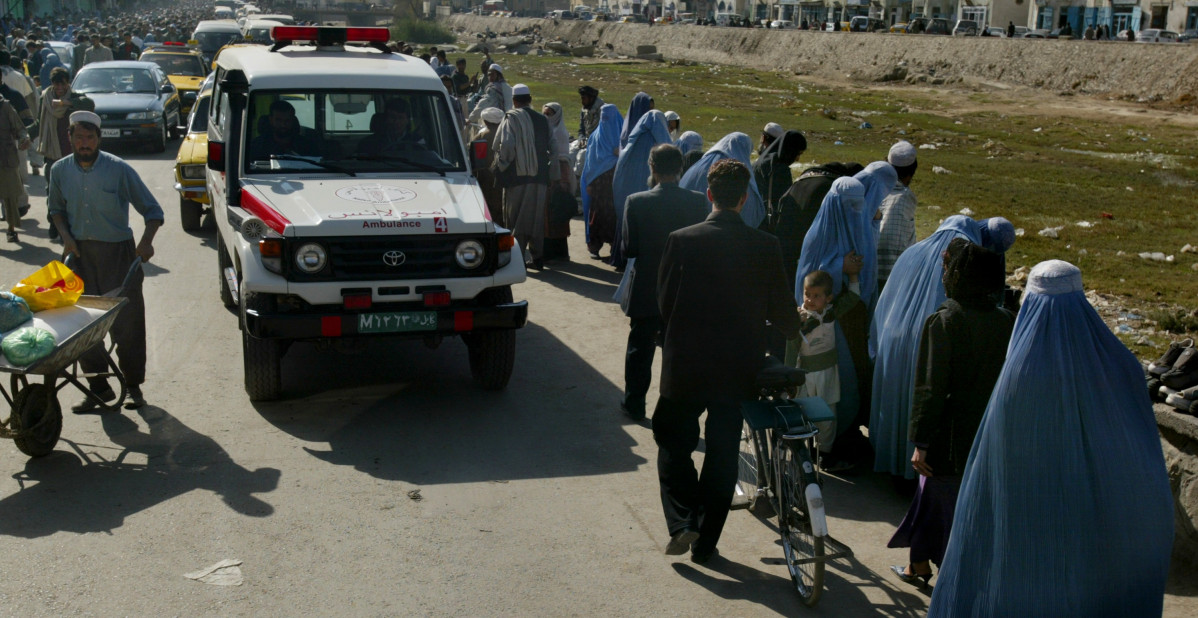 Archivo - Archivo - Una ambulancia junto a una fila de mujeres con burka en Kabul, Afganistán
