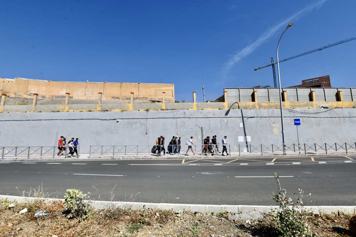 Varios migrantes procedentes de Marruecos hacen cola en las puertas de la frontera de Ceuta donde agentes de la Policía Nacional reparten citas para solicitud de asilo, a 2 de junio de 2021, en Ceuta (España).