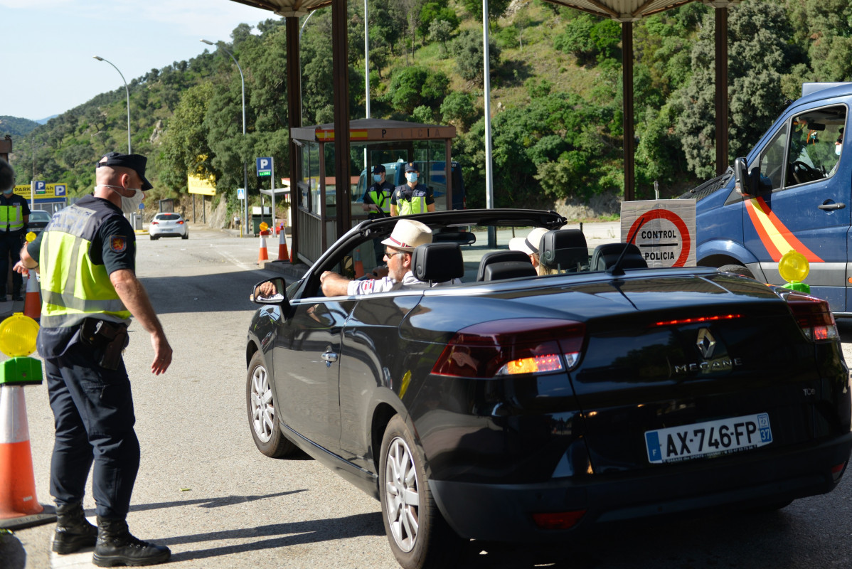 Un policía y un vehículo en la frontera de España con Francia en La Jonquera (Girona), en el primer día en el que se permite la libre circulación por el espacio Schengen tras levantarse las restricciones de movilidad por Covid- 19.