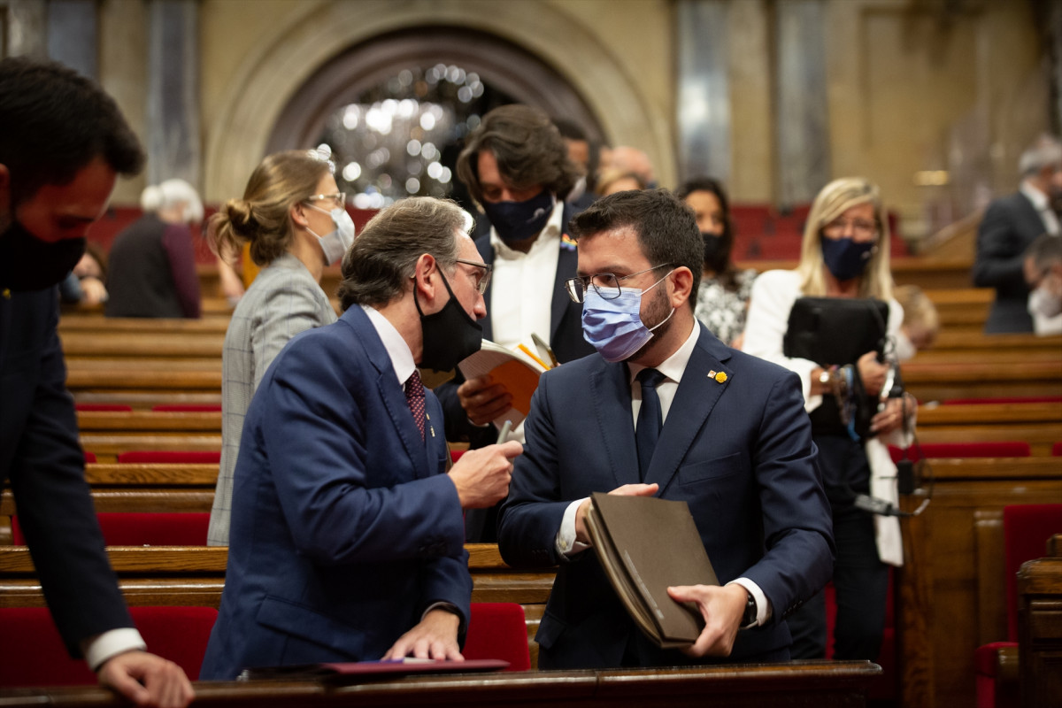 El presidente de la Generalitat, Pere Aragonés (d) y el consejero de Economía y Hacienda, Jaume Giró (i), en una imagen de archivo en el pleno del Parlamento.