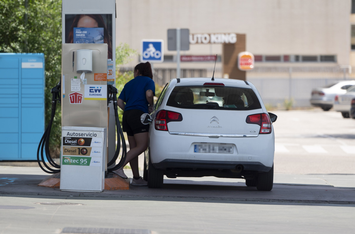 Archivo - Una mujer llena el dep&oacute;sito en una gasolinera
